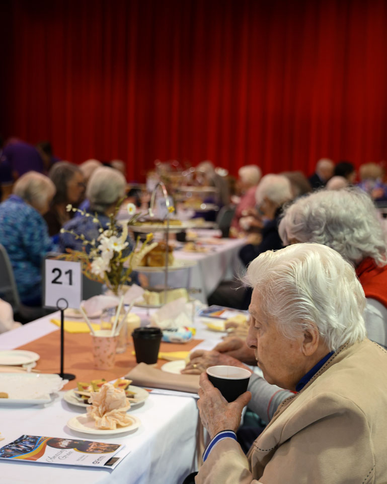 resident sipping a coffee at a table