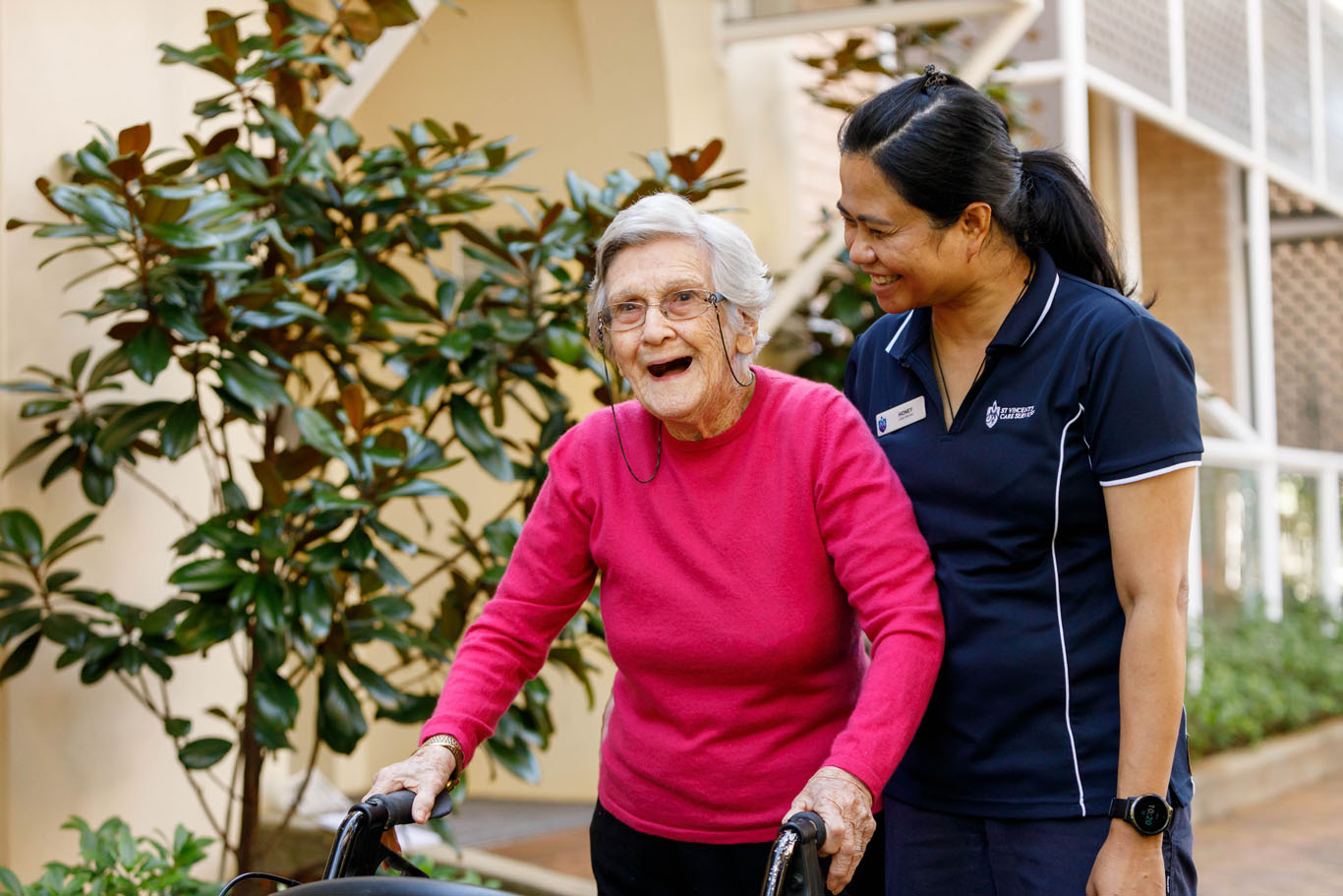 aged care worker walking with resident