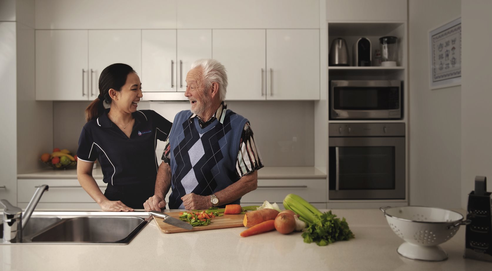 st vincent's staff member laughing in kitchen with home care client