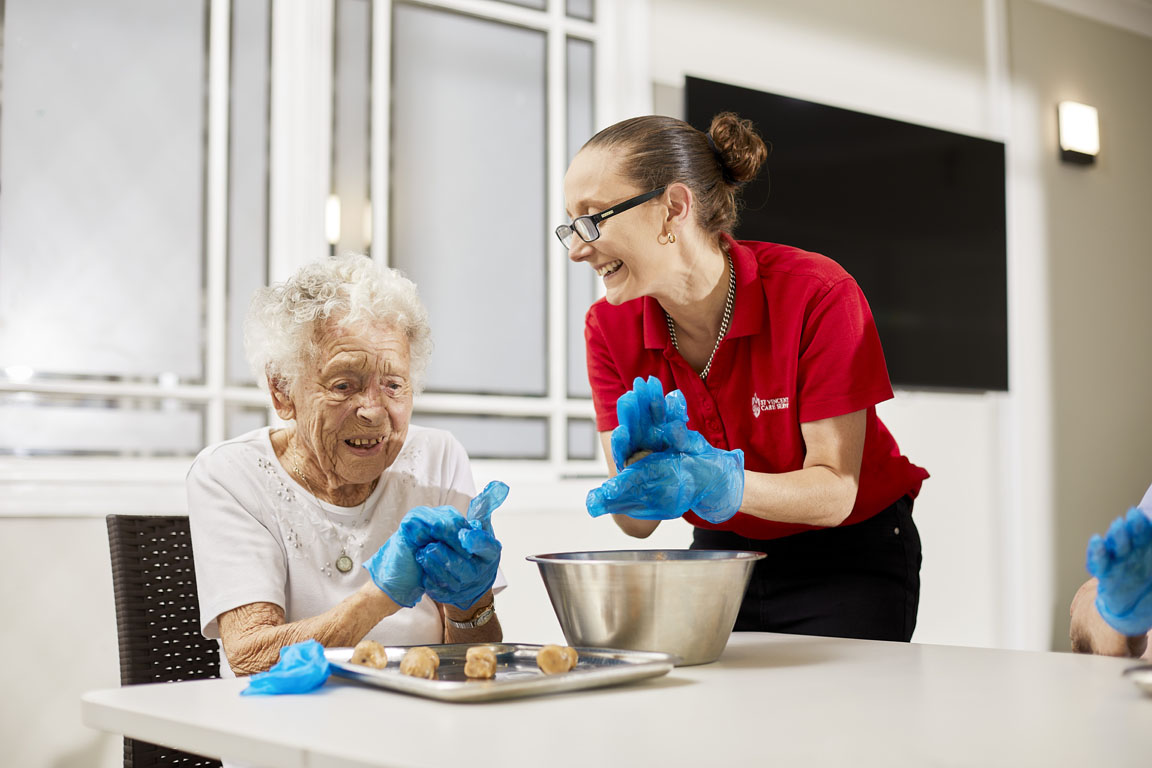 aged care staff member and residents cooking together